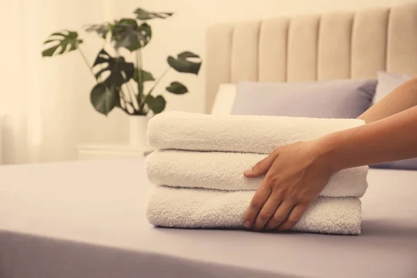 女性は柔らかいきれいなテリータオルをベッドの上に置きます クローズアップ — ストック写真