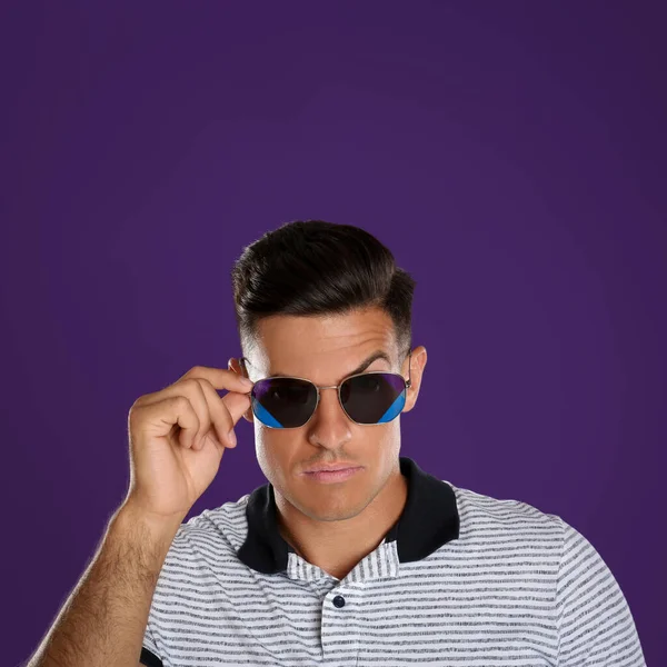 紫色の背景にサングラスをかけたハンサムな男 — ストック写真