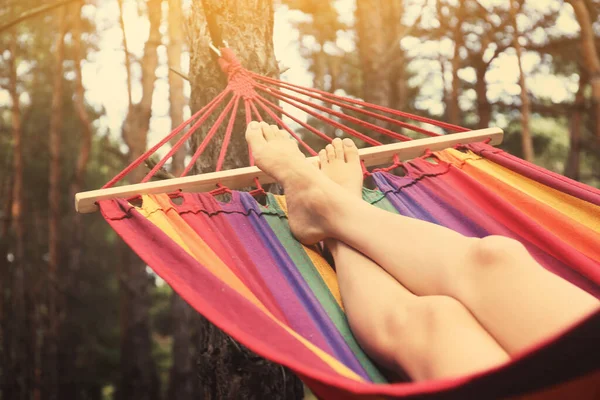 Woman resting in hammock outdoors on summer day, closeup