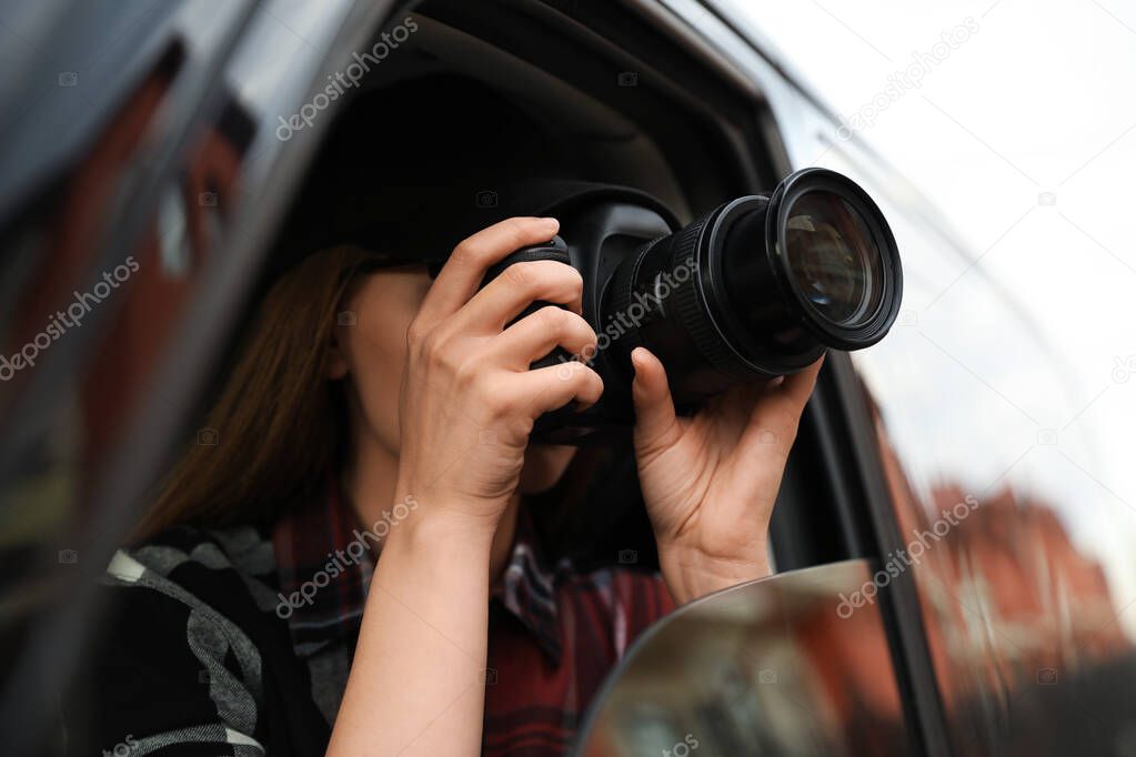 Private detective with camera spying from car