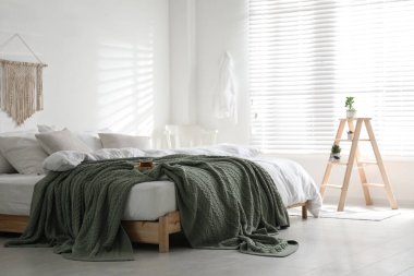 Odanın içinde sıcak örülmüş ekoseli rahat bir yatak.