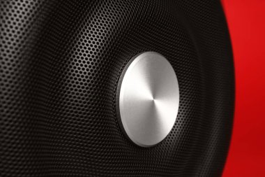 Kırmızı arka planda modern subwoofer, yakın plan. Güçlü ses hoparlörü