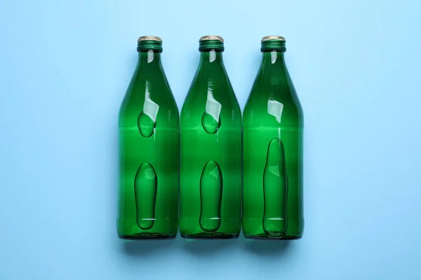 Γυάλινα Μπουκάλια Νερό Ανοιχτό Μπλε Φόντο Επίπεδη Lay — Φωτογραφία Αρχείου