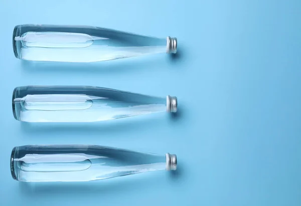 Γυάλινα Μπουκάλια Νερό Γαλάζιο Φόντο Επίπεδα Lay Χώρος Για Κείμενο — Φωτογραφία Αρχείου