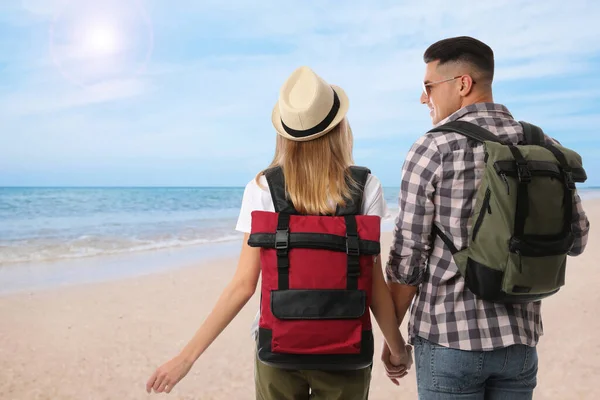 Viajeros Con Mochilas Playa Arena Cerca Del Mar Durante Viaje — Foto de Stock