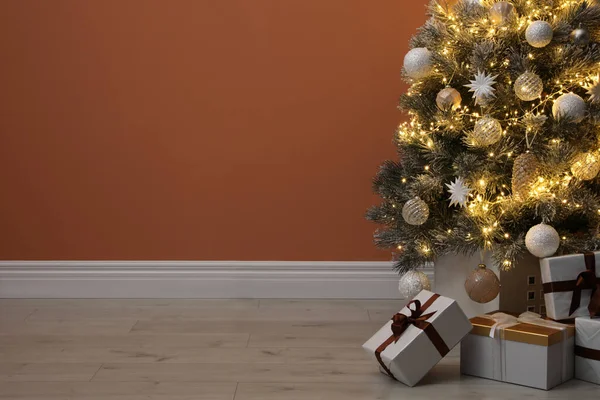 Beautiful Decorated Christmas Tree Glowing Fairy Lights Presents Orange Wall — Φωτογραφία Αρχείου