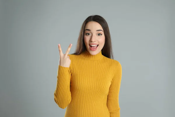 Woman Yellow Turtleneck Sweater Showing Number Two Her Hand Grey — Φωτογραφία Αρχείου