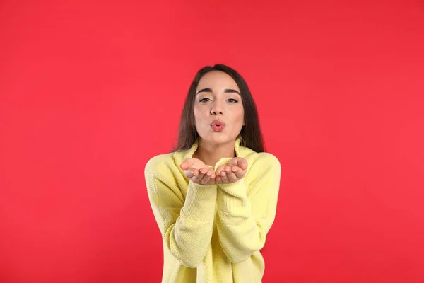 Hermosa Mujer Joven Con Suéter Amarillo Cálido Sobre Fondo Rojo — Foto de Stock