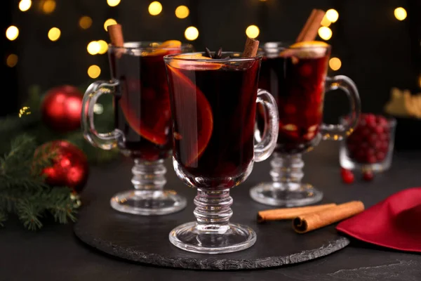 Aromatyczne Grzane Wino Czarnym Stole Przed Rozmazanymi Światłami Świątecznymi — Zdjęcie stockowe