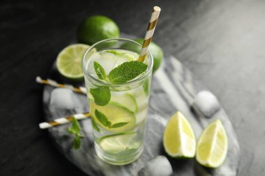 Lezzetli mojito ve siyah masadaki malzemeler