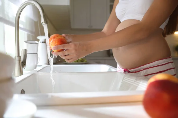 Młoda Ciężarna Kobieta Myjąca Świeżą Brzoskwinię Kuchni Zbliżenie Dbanie Zdrowie — Zdjęcie stockowe