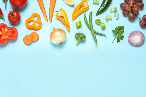 Fresh organic fruits and vegetables on light blue background, flat lay. Space for text