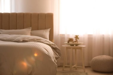 Pencereye yakın yumuşak battaniyeli rahat bir yatak.