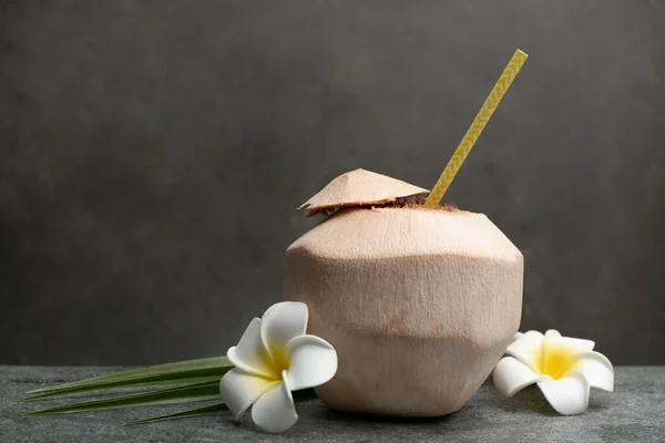 Junge Geschälte Kokosnuss Mit Stroh Palmblatt Und Blumen Auf Grauem — Stockfoto