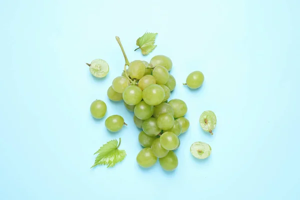 Stelletje Rijpe Druiven Met Groene Bladeren Lichtblauwe Achtergrond Vlak Gelegd — Stockfoto