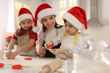 Anne ve küçük tatlı çocukları mutfakta Noel kurabiyesi yapıyorlar.