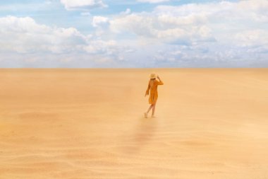 Güneşli bir günde çölde yürüyen bir kadın