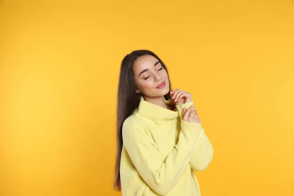 Wanita Muda Cantik Mengenakan Sweater Hangat Dengan Latar Belakang Kuning — Stok Foto