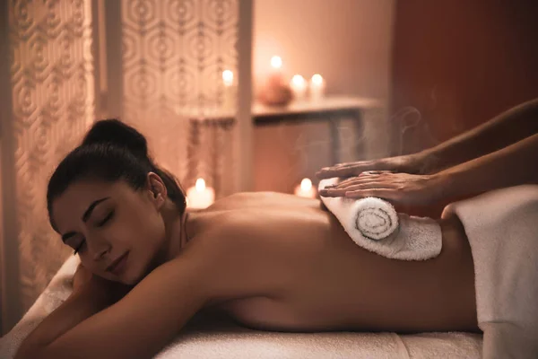 Młoda Kobieta Otrzymuje Gorący Masaż Ręcznikiem Salonie Spa — Zdjęcie stockowe