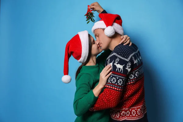 Felice Coppia Baciare Sotto Vischio Mazzo Sfondo Azzurro — Foto Stock
