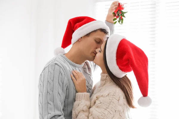 Feliz Pareja Santa Sombreros Besándose Bajo Muérdago Manojo Casa —  Fotos de Stock