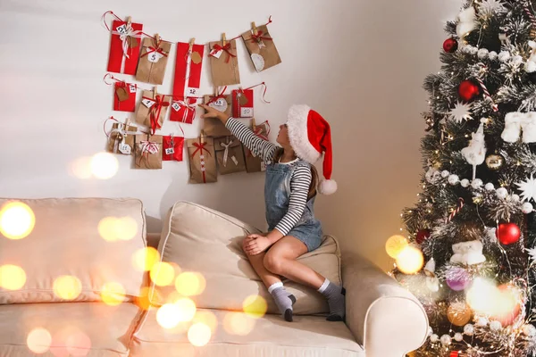 Sød Lille Pige Santa Hat Tager Gave Fra Jul Adventskalender - Stock-foto