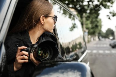 Kameralı özel dedektif arabadan gözetliyor.