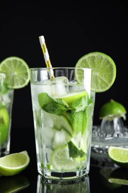 Lezzetli mojito ve siyah arka plandaki malzemeler.