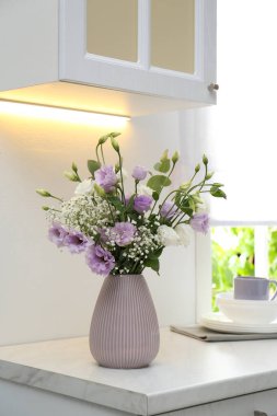 Mutfaktaki tezgahın üstünde Eustoma çiçekleri olan güzel bir buket.