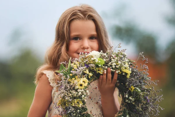 可愛いです女の子保持花輪で作られた美しい花屋外 — ストック写真