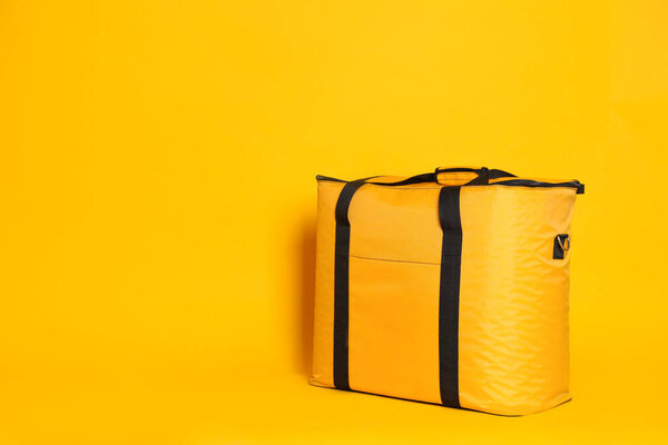 Modern thermo bag on yellow background. Space for text
