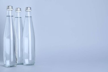Beyaz zemin üzerinde su olan cam şişeler, metin için boşluk
