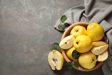 Gri masa üzerinde yaprakları olan taze, organik ayva. Metin için boşluk
