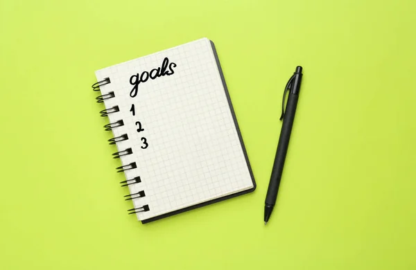 Σημειωματάριο Λίστα Στόχων Και Στυλό Πράσινο Φόντο Επίπεδη Lay — Φωτογραφία Αρχείου