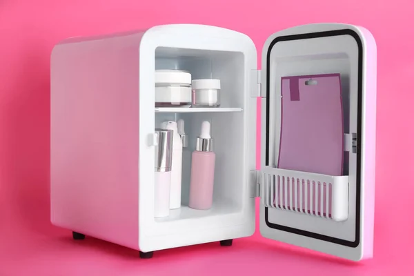 Pembe Arka Planda Cilt Bakım Ürünleriyle Birlikte Açık Kozmetik Buzdolabı — Stok fotoğraf