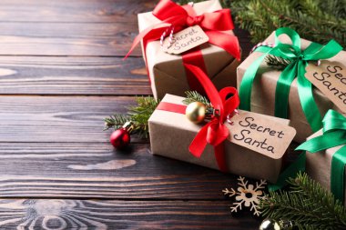 Gizli Noel Baba hediyeleri ve Noel dekorasyonu ahşap masada, mesaj için yer var.