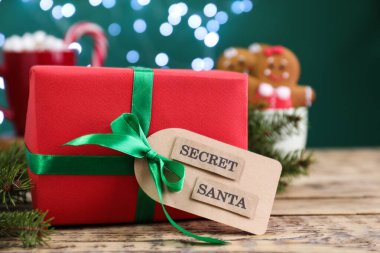 Gizli Noel Baba 'dan bulanık ışıklara karşı ahşap masada hediye.