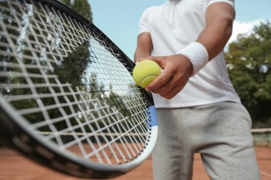 Sporcu sarayda tenis topu servis etmeye hazırlanıyor, yakın plan.