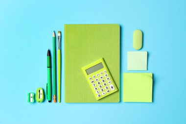 Düz kompozisyon ve açık mavi arka planda farklı okul kırtasiyesi. Okula geri dön.