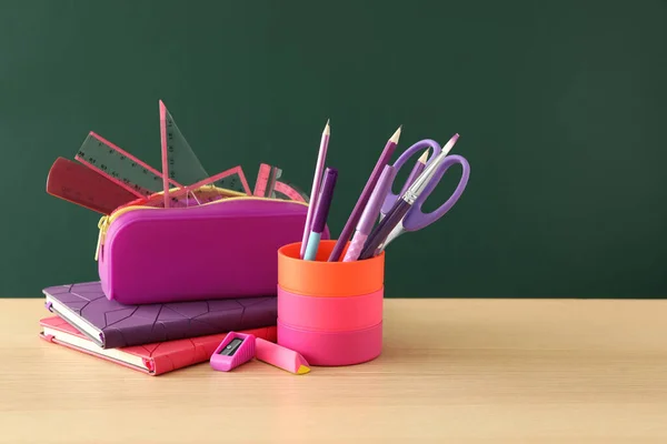 Verschiedene Schulschreibwaren Auf Einem Holztisch Neben Einer Grünen Tafel Zurück — Stockfoto