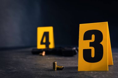 Mermi kovanları ve kanıt işaretleri siyah tahta üzerinde, yakın plan. Suç mahalli
