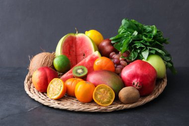 Gri masada taze egzotik meyveler var.