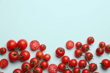 Açık mavi arka planda taze vişneli domatesler. Metin için boşluk