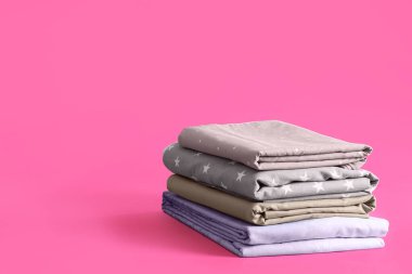 Pembe arka planda bir yığın temiz çarşaf. Metin için boşluk