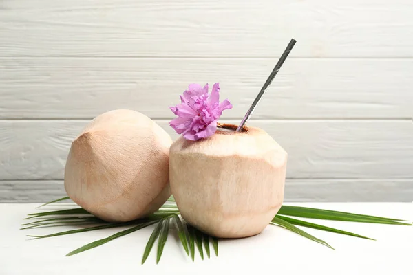 Jonge Geschilde Kokosnoten Met Stro Palmblad Bloem Witte Houten Tafel — Stockfoto