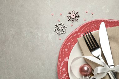 Gri arka planda güzel bulaşık takımları ve Noel dekoruyla şenlik masası. Metin için boşluk