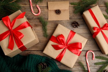 Düz kompozisyon, hediye kutuları ve ahşap masa üzerindeki Noel süslemeleri.