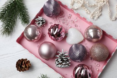 Düz kompozisyon ve beyaz ahşap masa üzerinde güzel Noel süsleri.