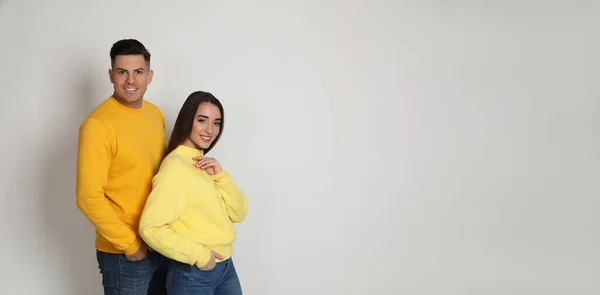 Pareja Feliz Usando Suéteres Cálidos Amarillos Sobre Fondo Blanco Espacio — Foto de Stock