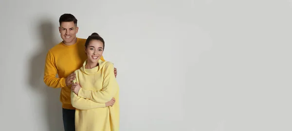 Pareja Feliz Vistiendo Suéteres Cálidos Amarillos Sobre Fondo Blanco — Foto de Stock